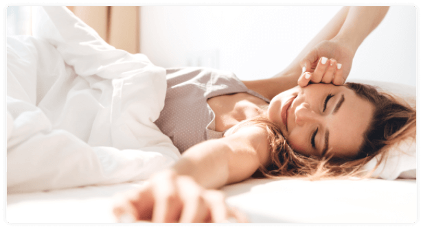 uma mulher deitada na cama com os olhos fechados